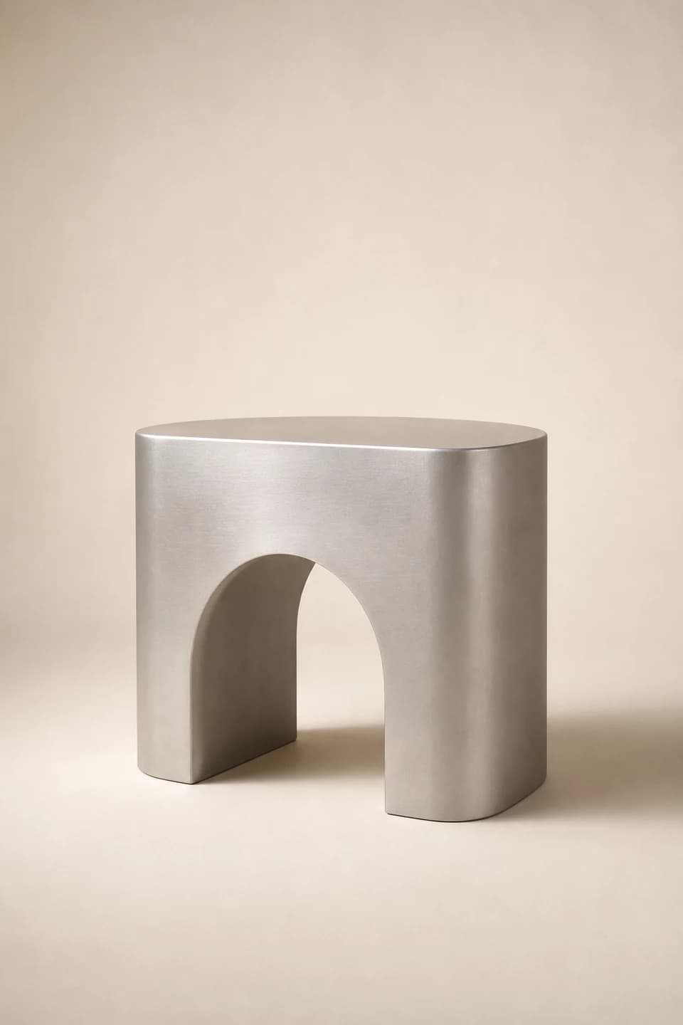 Brushed aluminum side table with an arched opening